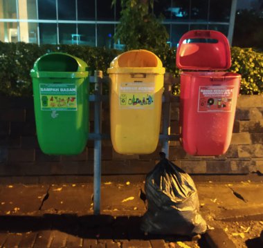 Jakarta, Endonezya - 12 Ocak 2022 Toplum içinde farklı renklere sahip çöp kutusu organik, inorganik ve B3 tehlikeli atıkları ayırmak için.