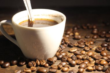 cup of coffee and roasted coffee beans on the wooden table