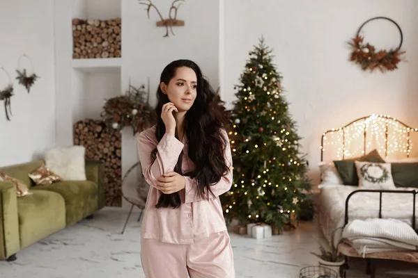 Hübsches Model-Mädchen mit dunklen Haaren trägt modische Nachtwäsche und posiert für Weihnachten dekoriert — Stockfoto