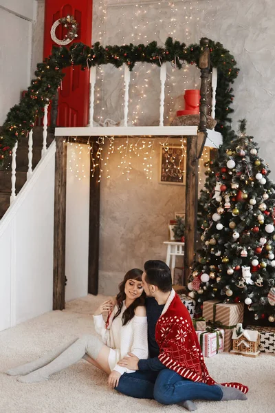Heureux couple hétérosexuel câlins ensemble dans un salon décoré pour Noël — Photo