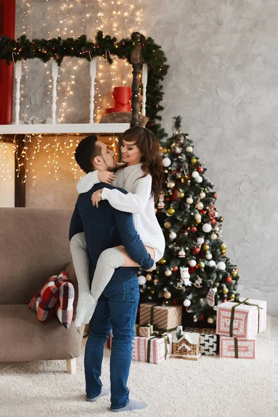 Jeune couple doux posant dans le salon intérieur décoré pour les vacances de Noël — Photo