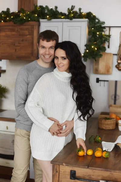 Молода пара, красивий чоловік і красива дівчина-модель позує на прикрашеній кухні в різдвяний ранок — стокове фото