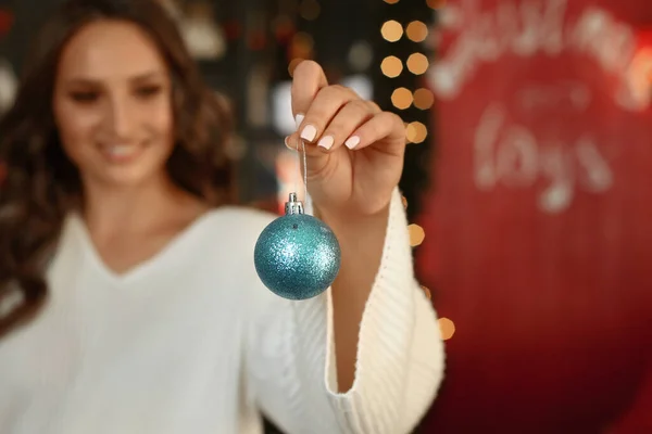Feestelijk kerstspeelgoed voor kerstboom in een vrouwelijke hand — Stockfoto