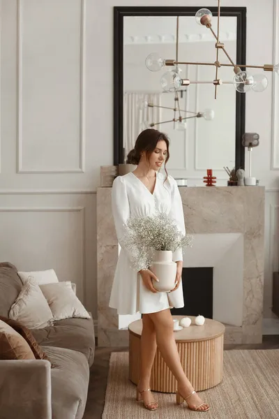 En modern modell flicka i en elegant vit klänning utgör på vintage vardagsrum — Stockfoto