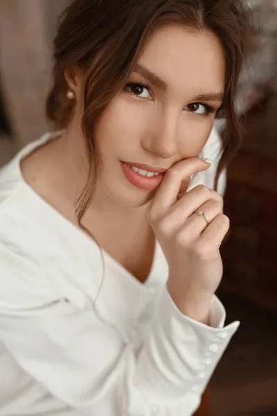 一个时髦的年轻女子，拥有完美的黑发和完美的时髦化妆在优雅的白色连衣裙。美丽的棕色头发模特，双唇丰满迷人 — 图库照片