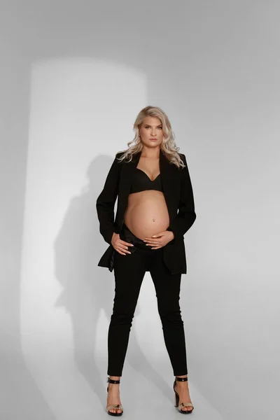 Модный портрет беременной женщины в полный рост на белом фоне — стоковое фото