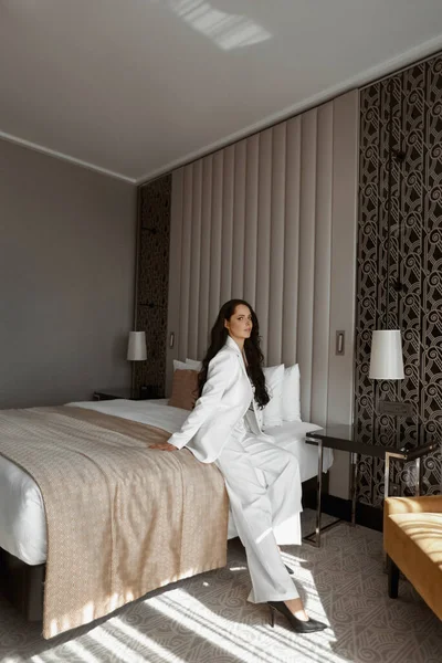 A model girl in white suit posing in bedroom — Stock Photo, Image