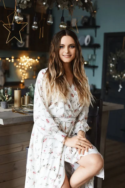 Menina modelo de beleza adorável com maquiagem moderna e surpreendentes olhos azuis em um vestido elegante posando na sala de jantar decorada para o jantar de Natal — Fotografia de Stock