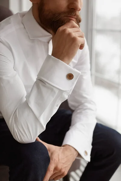 Обрізаний портрет елегантного красивого хлопця, молодого бородатого бізнесмена, або стильного нареченого в білій сорочці з модними запонки на сорочках — стокове фото