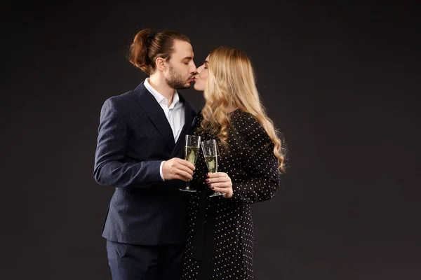 Sweet couple of lovers holding champagne glasses and kissing on the dark background. Concept of 14th February mockup - st. Valentines day — Fotografia de Stock