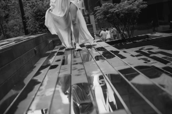 Beyaz Elbiseli Kız Islak Ahşap Zeminde Birikintisinde Koşuyor — Stok fotoğraf