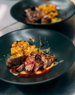 Siyah tabakta kırmızı soslu kızarmış et.