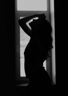 Siluet kadın ellerini kaldırır ve sabah neşeli saçlarına dokunur