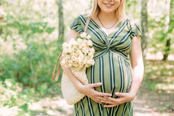 在夏日阳光普照的公园外面开着袋花的孕妇 — 图库照片