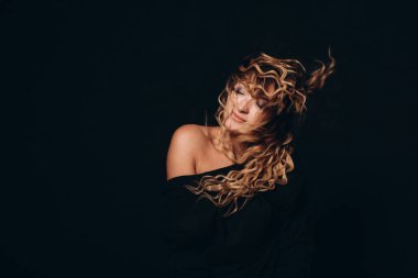 curly hairstyle blonde woman model studio black backgroun