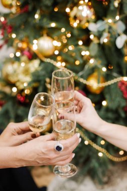 Bir Noel ağacının arka planında üç şarap kadehi. Kutlama çelenkleri ve süslemeler.