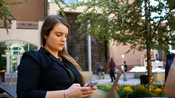 Şehir merkezindeki Akıllı Telefonla Mesajlaşan Genç Proffessional Woman