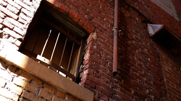 Korumalı paslı parmaklıkları olan kumlu bir sokak penceresi