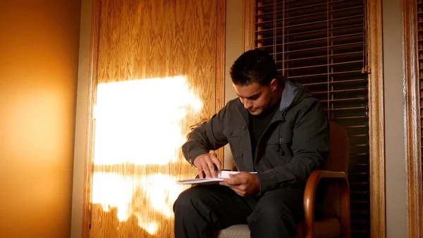 Doktorların ofisinde ya da iş başvurusunda evrak dolduran genç adam.