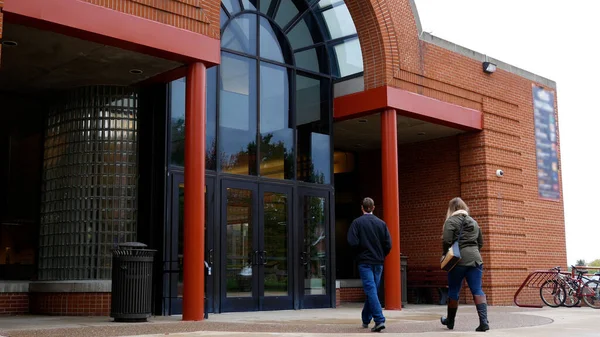 İki üniversite öğrencisi genel öğrenci birliği binasına giriyor.