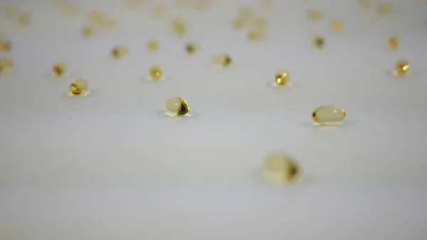 Beyaz Arkaplan üzerinde dönen D vitamini kapsüllerini temizle