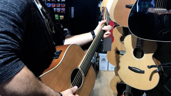 Erkek müzisyen İrlanda 'da müzik dükkanında gitar çalıyor