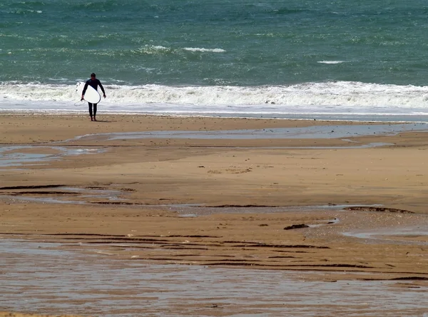 Серфер, гуляющий по пляжу — стоковое фото