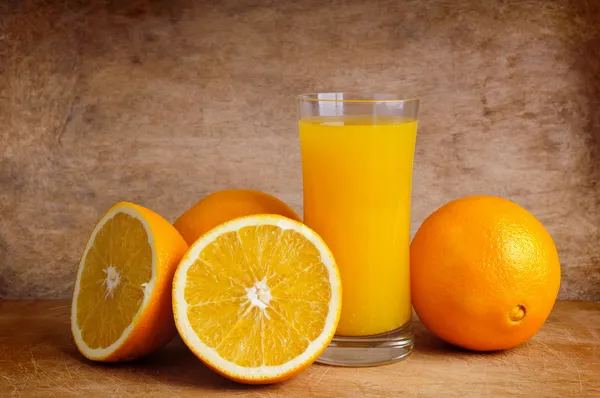 Frischer Orangensaft und Orangen — Stockfoto