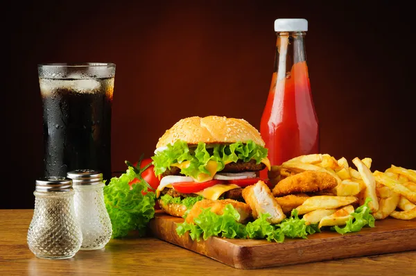 Hambúrguer, pepitas de frango, batatas fritas, cola e ketchup — Fotografia de Stock