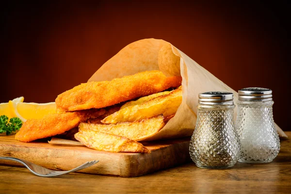 Pescado y patatas fritas envueltos en papel — Foto de Stock