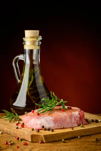 Raw pork meat steak and olive oil — Stock Photo, Image