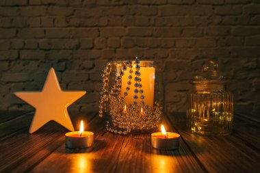 Karanlıktaki yıldız, karanlık bir arkaplanda noel mumları ve süslemeleri.