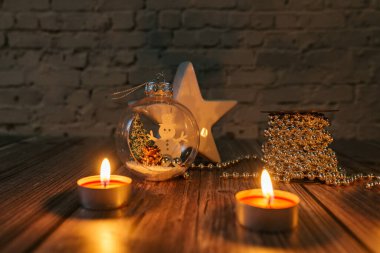Karanlıktaki yıldız, karanlık bir arkaplanda noel mumları ve süslemeleri.