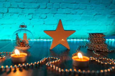 Karanlıktaki yıldız, mavi arka plandaki Noel mumları.