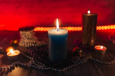  Kırmızı arka planda Noel mumları ve süslemeleri.