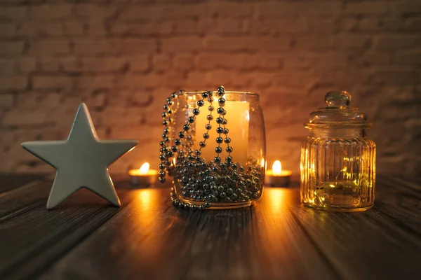 Karanlıktaki yıldız, Noel mumları ve sarı arka plandaki süslemeler.