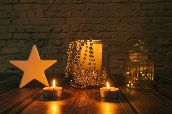 Karanlıktaki yıldız, karanlık bir arkaplanda noel mumları ve süslemeleri.