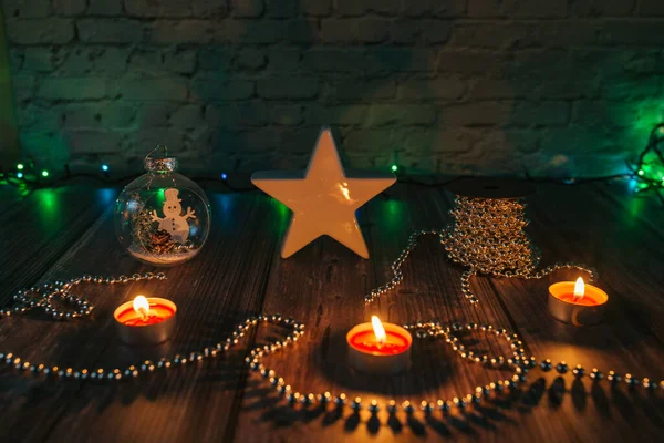 Karanlıktaki yıldız, karanlık bir arkaplanda noel mumları ve süslemeleri.
