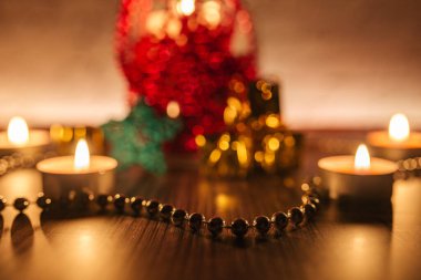 Yakın plan mum ışıkları, kırmızı ve altın Noel süslemesi kırmızı arka planda