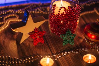 Noel sofrasında mumlar ve ahşap arka planda hediyeler