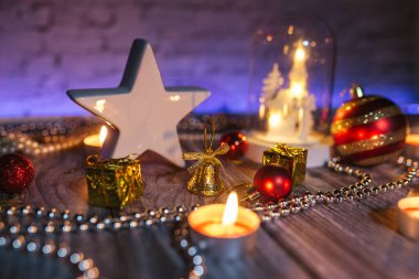 Yılbaşı mum ışığı, ışıklarla dekorasyon, masada yıldız ve kilise.