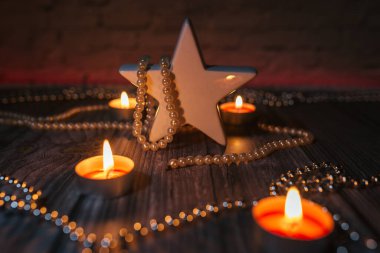 Noel mum ışığı, kırmızı ışıkta süsleme, masada yıldız.