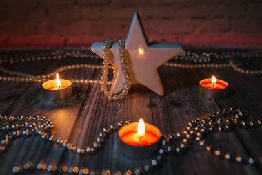 Mum ışığı, kırmızı ışıkta süsleme, masada yıldız.