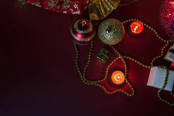 平置きのクリスマスボール赤い背景にろうそくの飾り — ストック写真