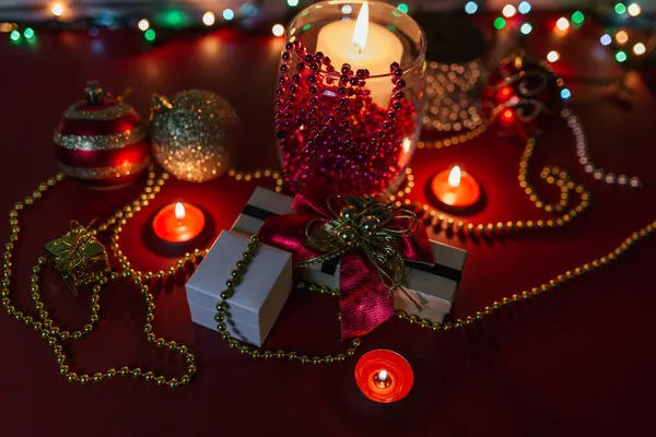 クリスマスプレゼント赤い背景にろうそくの飾り — ストック写真
