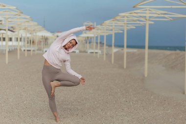 Yoga antrenmanı, pembe kapüşonlu kız dengeni koru.