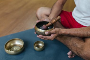 Şarkı kaseleriyle oynayan bir adamın yakın çekim elleri. Rahatlama ve meditasyon. Tibet şarkı kaseleri.