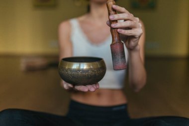 Şarkı kâseleriyle oynayan bir kadının yakın çekim elleri. Rahatlama ve meditasyon. Tibet şarkı kaseleri.