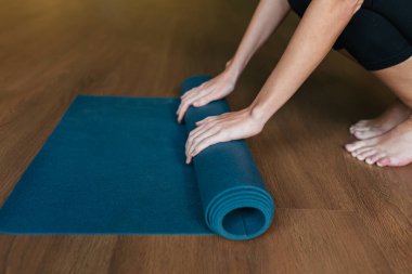  Mavi yoga minderini elinde tutan bir kızın yakın çekimi..