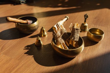 Tibet şarkı kaseleri, çanlar, meditasyon ve ahşap zeminde rahatlama için. Palo Santo ormanı tütsülüyor. Ses masajı ve iyileşme.